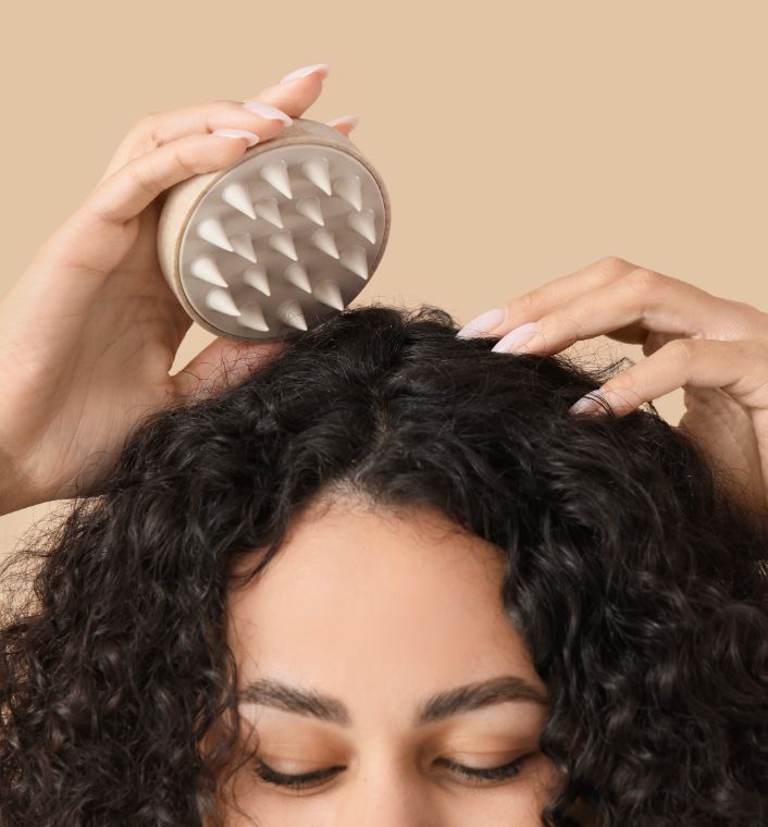 A natural-haired woman carrying out a simple scalp-care routine.
