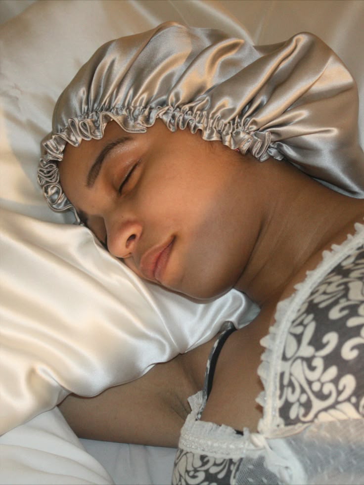 Woman wearing a satin bonnet to protect 4C hair overnight.