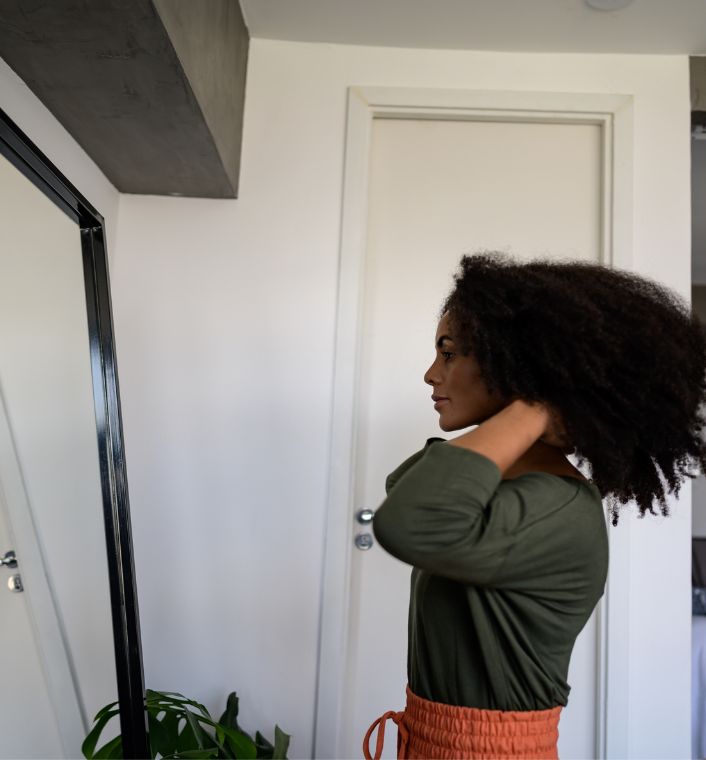 Black woman examining her natural 4C hair after wash day.