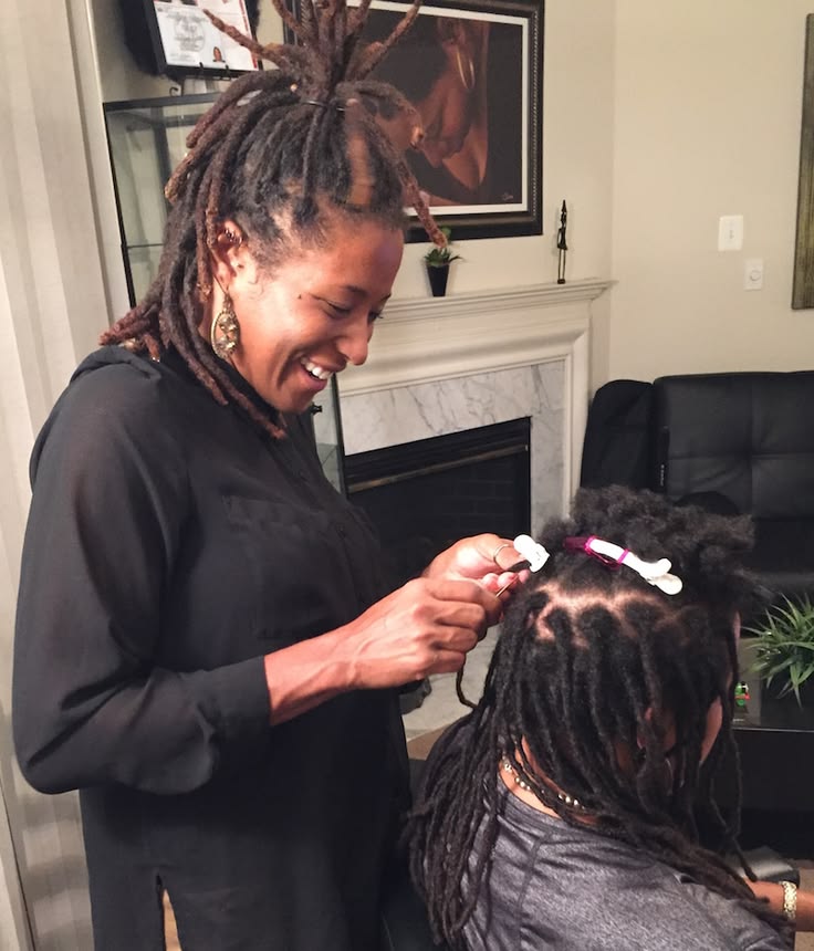 Professional loctician installing neat starter locs on natural 4C hair.