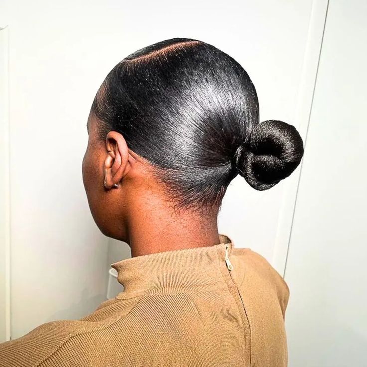 Black woman with natural 4C hair in a tight repeated ponytail style
