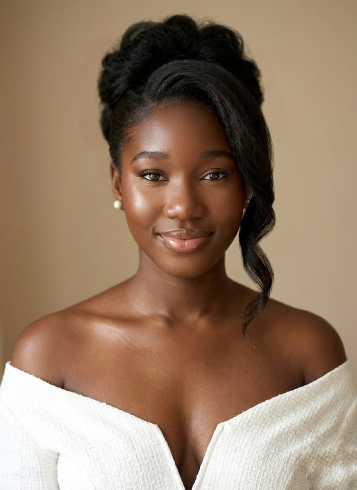 Rounded updo with side fringe on natural 4C hair for a wedding