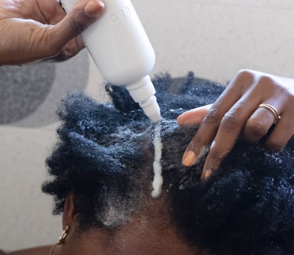  Shampoo being applied mainly to the scalp of natural 4C hair