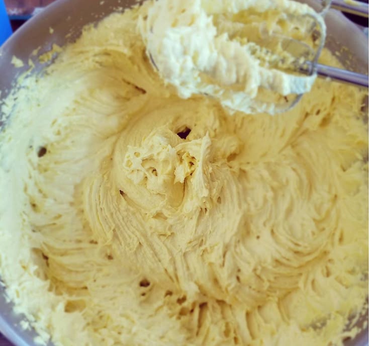 Whipped shea butter being prepared in a mixing bowl.
