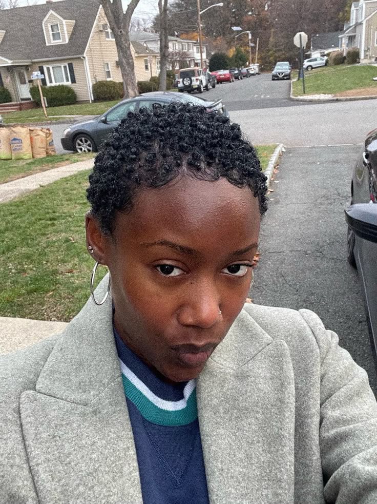 Woman embracing her short natural 4C hair after a big chop.