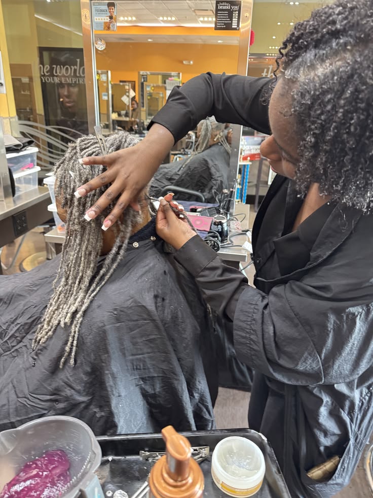 Professional loctician checking and maintaining healthy starter locs.