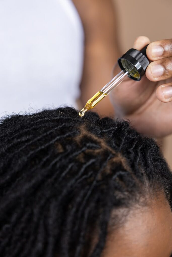 Black woman caring for her starter locs as part of her weekly hair routine.
