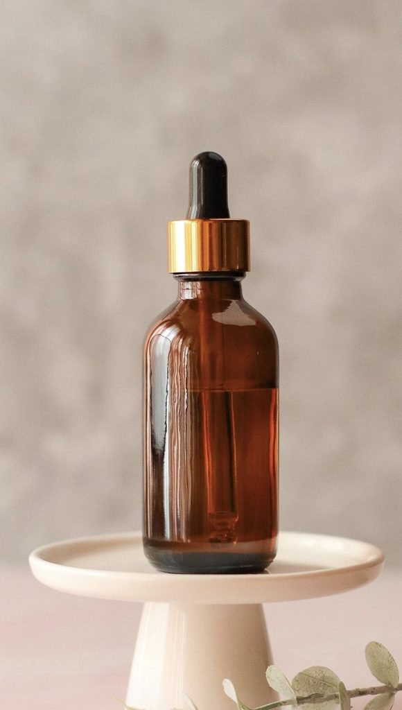 Homemade hair oil stored in an amber bottle