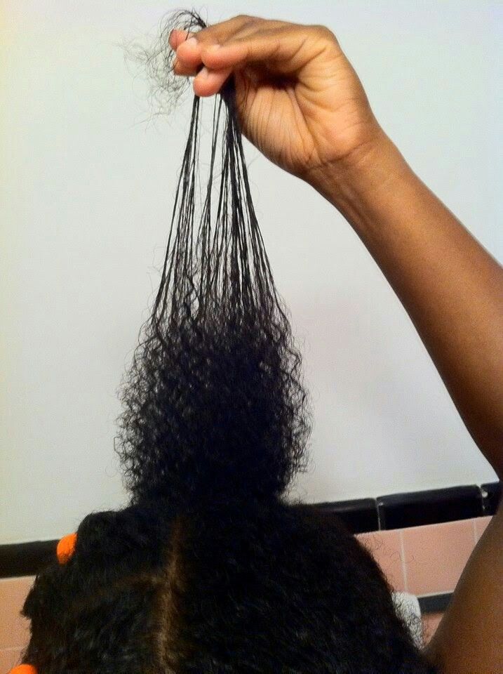 Black woman transitioning from relaxed hair to natural 4C hair with visible new growth.