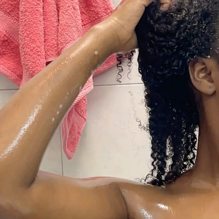 Woman washing natural 4C hair with a moisturizing shampoo.