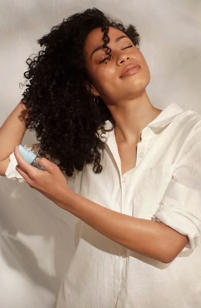 Healthy natural 4C hair being hydrated with water before applying products.