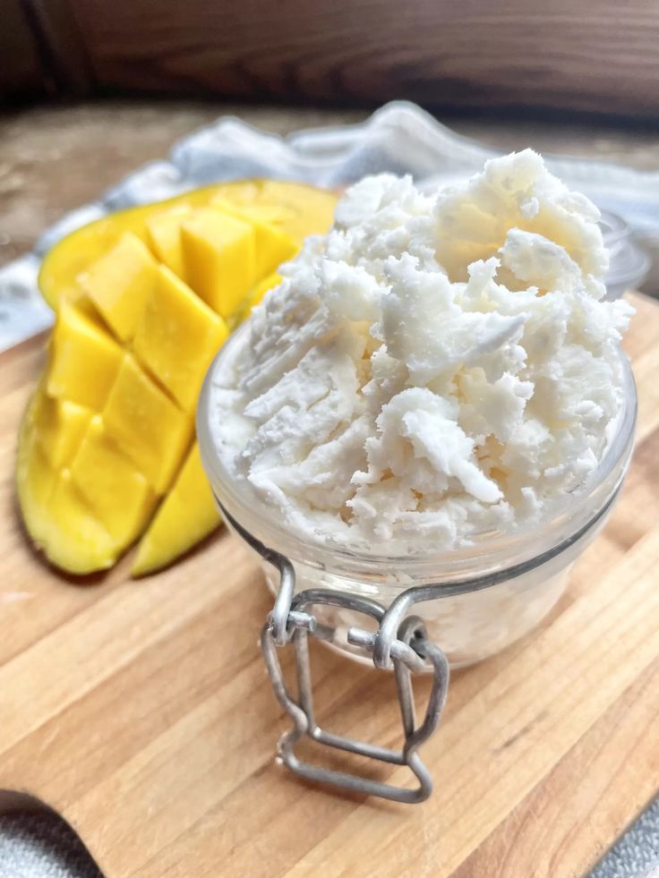 Fluffy whipped mango and shea butter in a glass jar.