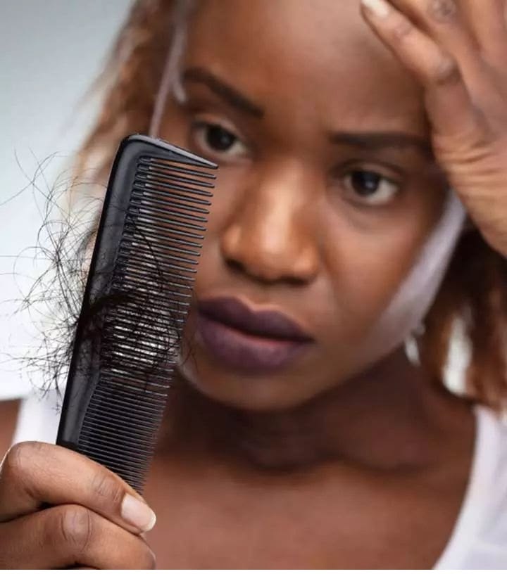 Black woman examining breakage in her natural hair
