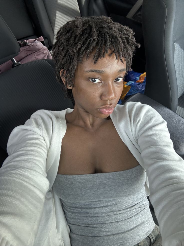 Woman with tightly coiled 4C hair wearing developing locs