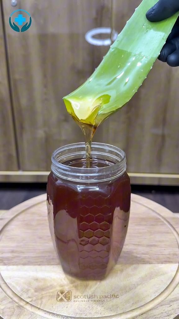 Aloe vera gel and honey being mixed in a small bowl.