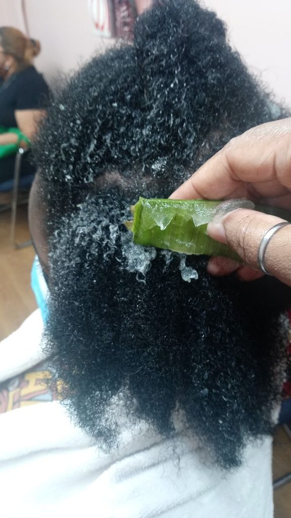 Aloe vera gel being gently applied to a clean scalp.