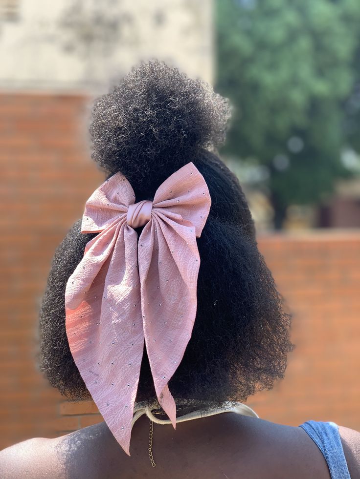 Natural hair styled with a decorative bow clip