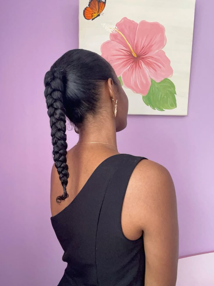 Woman wearing a long braided ponytail on natural hair
