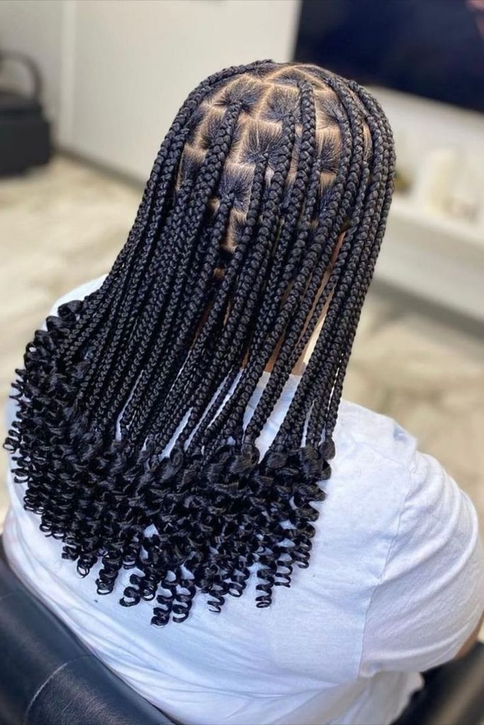Woman wearing long braids with curly ends
