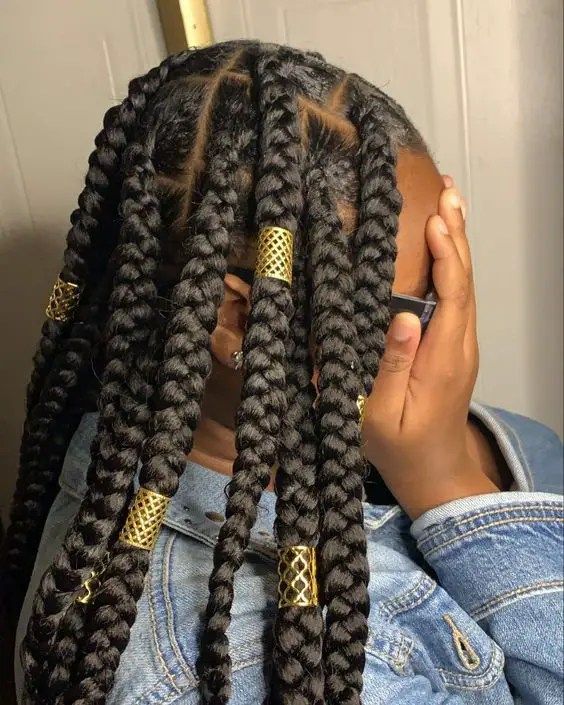 Woman wearing braids decorated with metallic hair cuffs