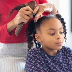 a woman patiently taking down her child's hair