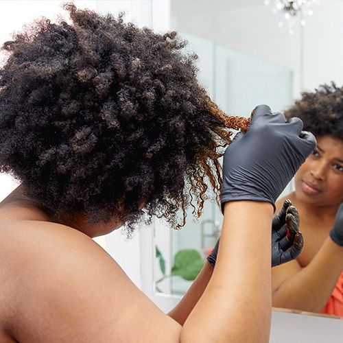 woman coloring her hair by herself at home