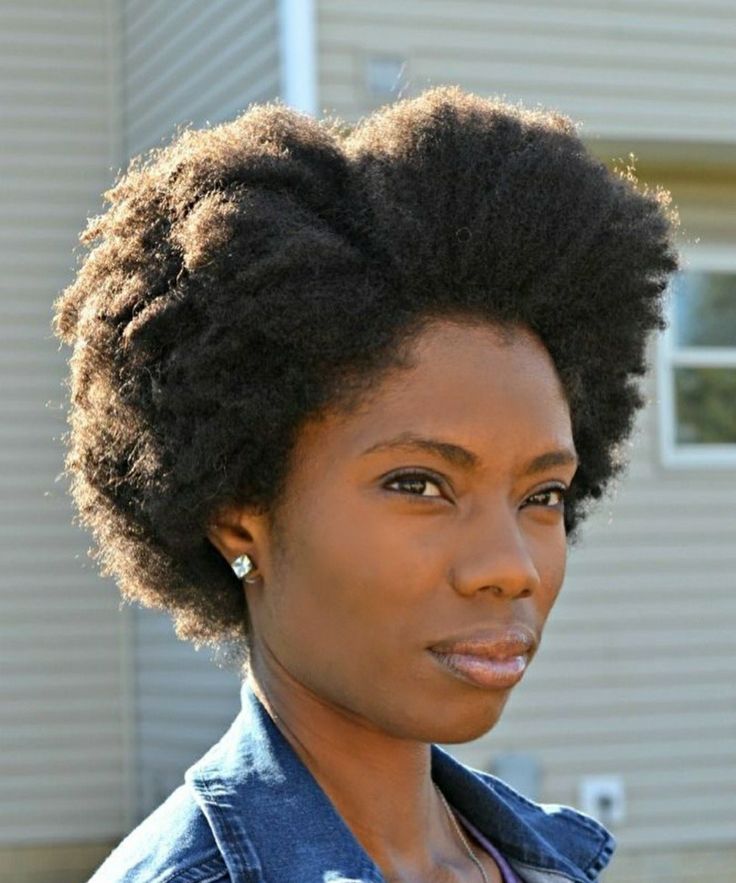 Woman proudly wearing fully natural 4C hair after transitioning