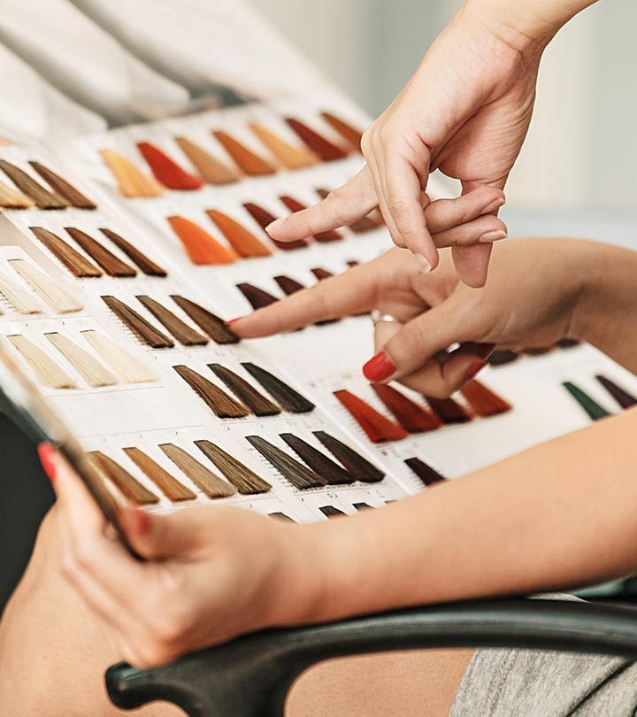 Black woman comparing warm and cool hair color shades for dark skin to choose from