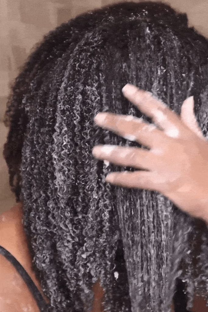 Woman deep conditioning her natural 4C hair during summer