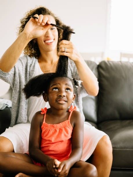 Parent gently detangling a child's 4C hair from the ends toward the roots