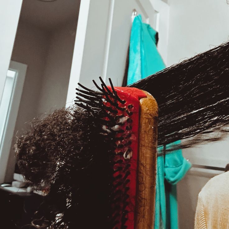 Woman gently detangling moisturized natural 4C hair in sections