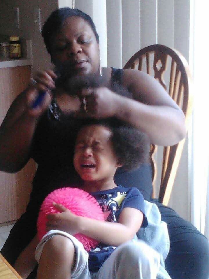 a woman detangling her kid's hair on wash day