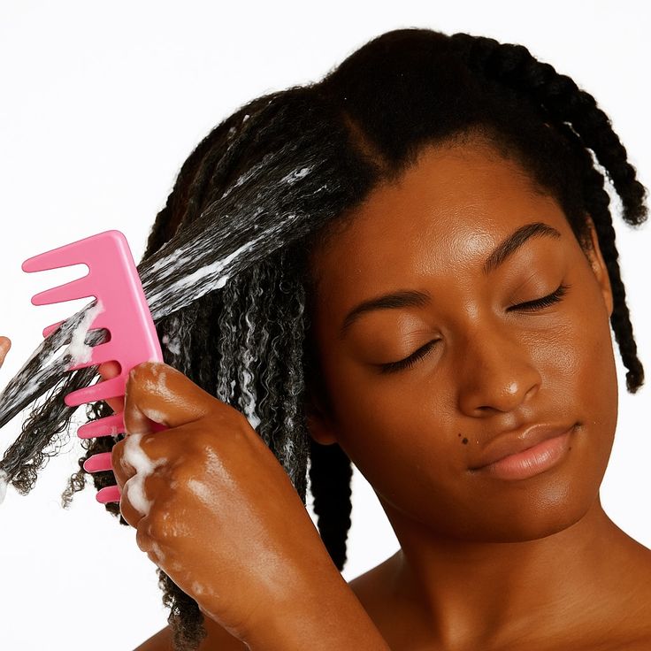 Woman gently detangling transitioning hair in sections