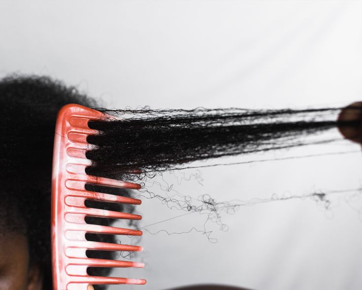 Woman gently detangling transitioning natural hair in sections