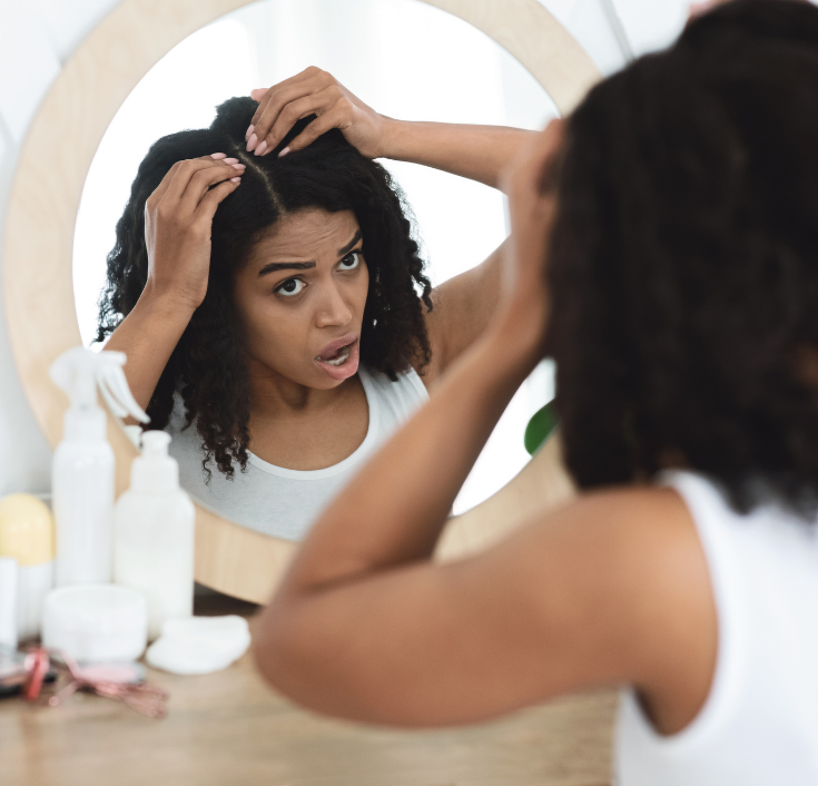 Woman checking her scalp during a fall natural hair routine
