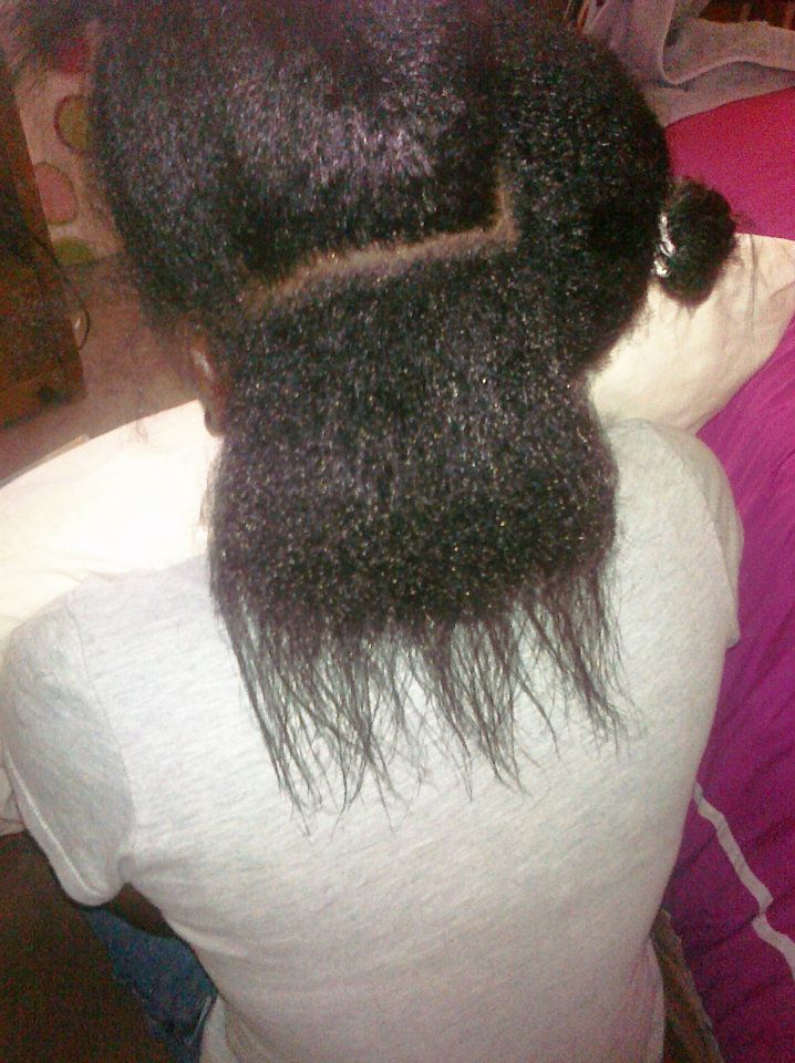 Woman checking natural hair growth after several months of transitioning