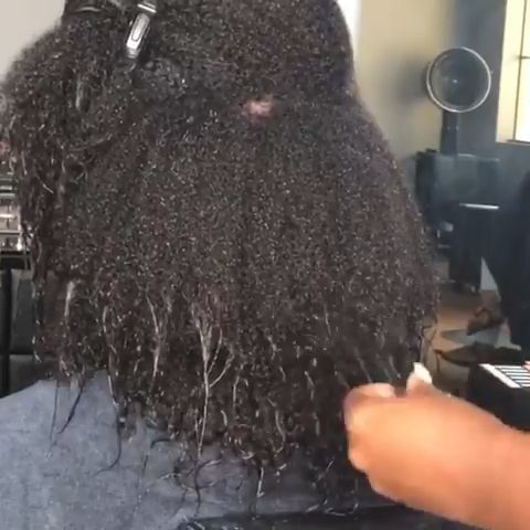 Woman preparing to cut relaxed ends after transitioning to natural hair