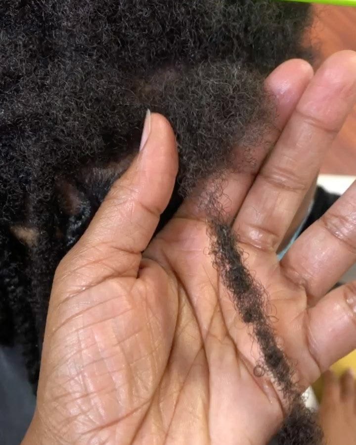 Loctician examining fine natural hair before installing small locs