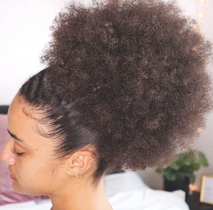 Woman wearing a full fluffy afro puff on natural 4C hair