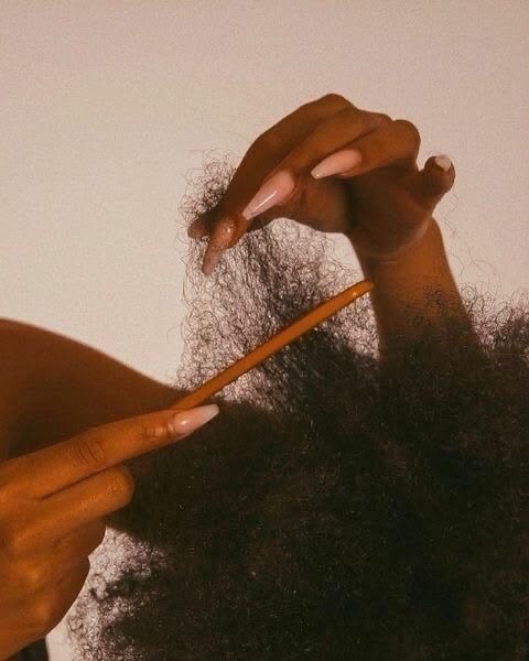 Parent gently loosening a stubborn knot from a child's 4C natural hair