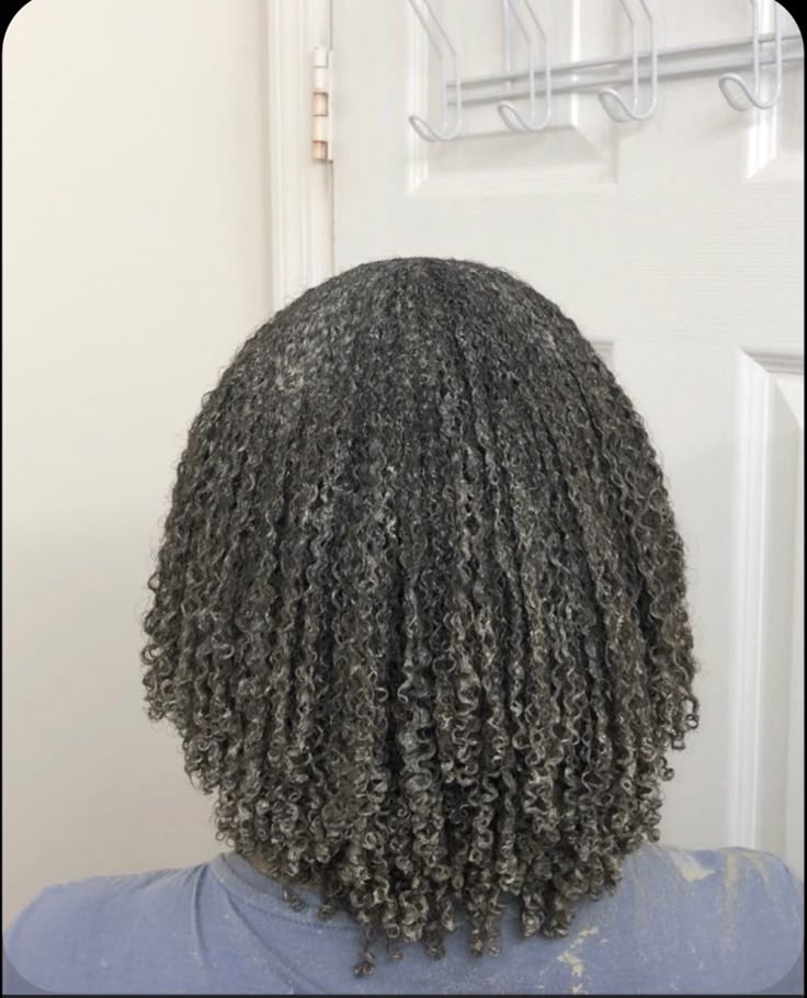 Woman applying a moisturizing hair mask to natural 4C hair