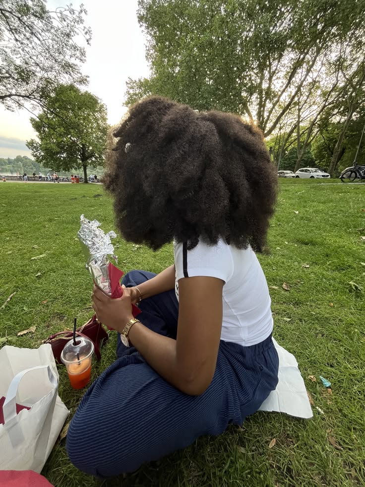 Woman with healthy natural 4C hair enjoying a summer day