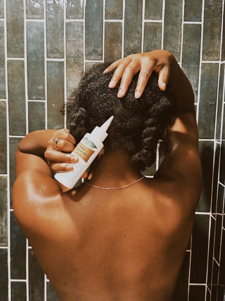 Woman caring for her scalp as part of a fall natural hair routine