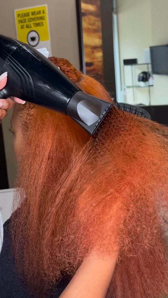 woman applying heat to colored hair