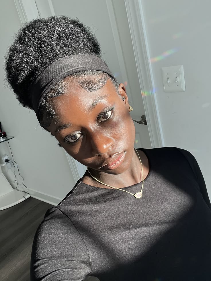 Woman wearing a high puff with a headband on natural hair for rainy day