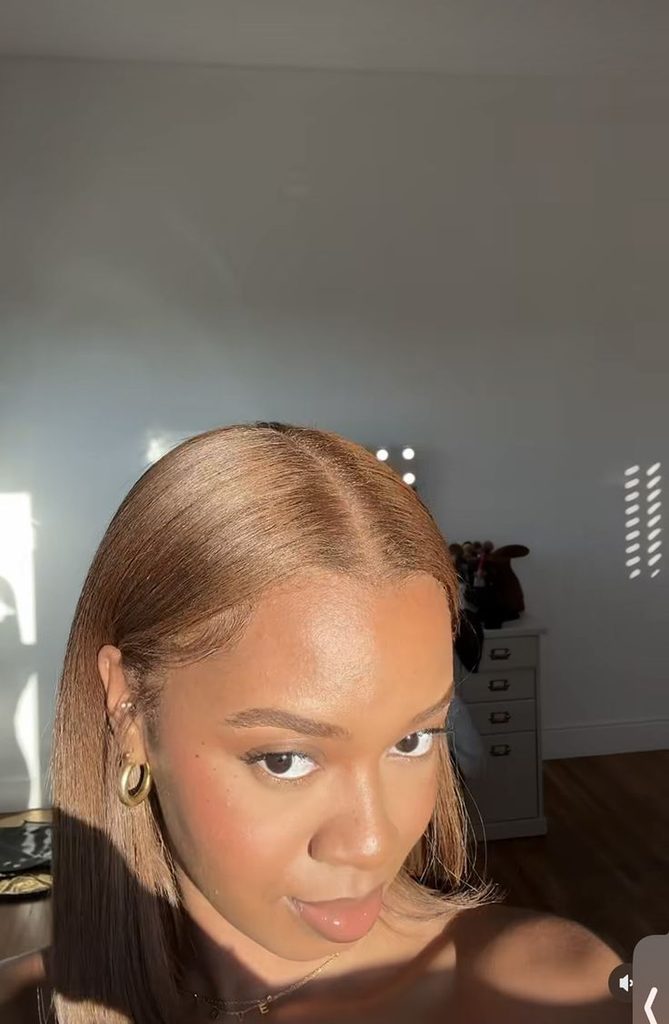 Black woman wearing honey brown natural hair against a deep complexion