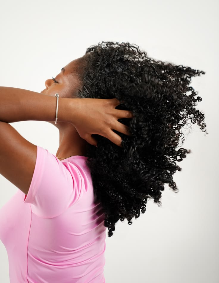 Woman gently caring for an itchy scalp with natural 4C hair