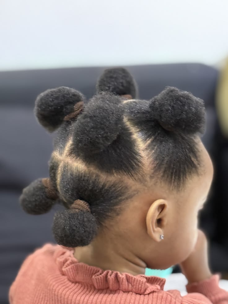 Black girl with natural 4C hair in multiple mini afro puffs with colorful bows
