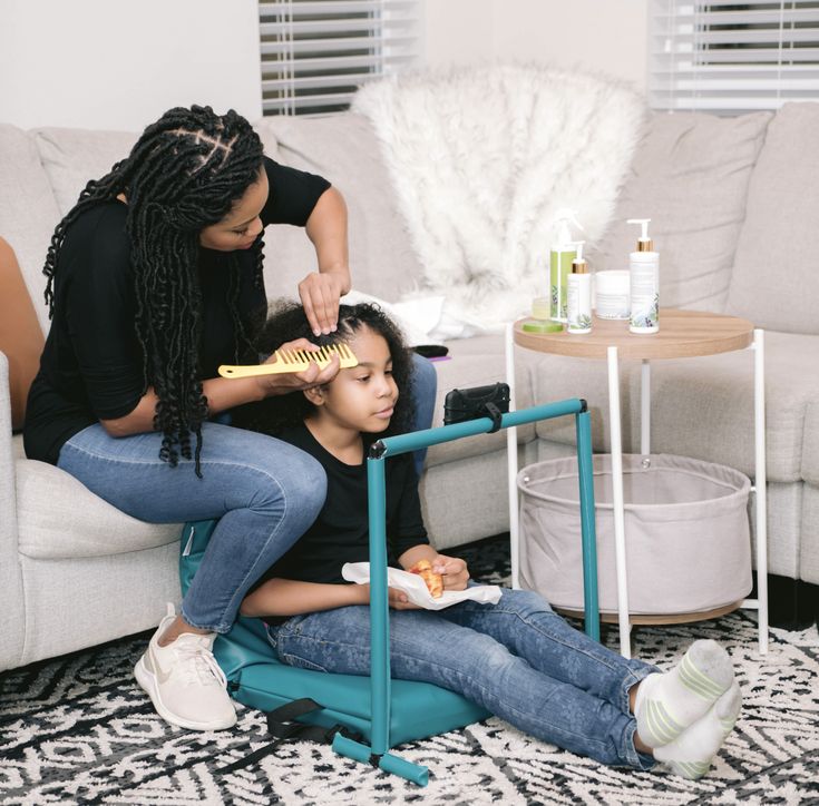 Parent preparing conditioner, spray bottle and detangling tools for a child's natural hair