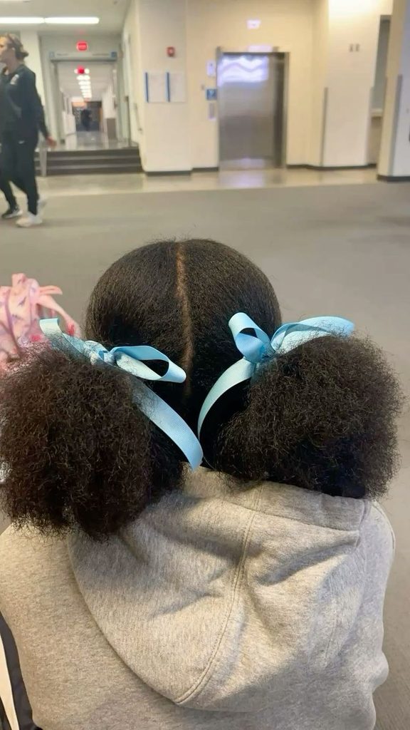 Two low ponytails on a child with 4C hair